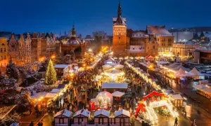 En livlig julmarknad i Gdansk med snö, julgranar och tusentals besökare som njuter av den magiska stämningen.
