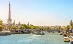 Eiffeltornet och Pont Alexandre III över Seine. En perfekt vy för en minnesvärd resa, kanske **2 dagar i Paris**? Båtar glider fram på vattnet.