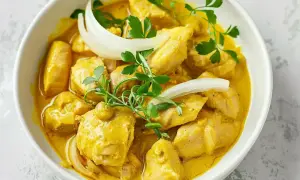 Kyckling i krämig currysås, perfekt för ett snabbt och gott currysås recept. Garnerad med lök och persilja.