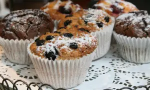 En korg med choklad muffins och blåbärsmuffins, pudrade med florsocker. Perfekt för fikat!
