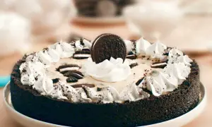 En krämig oreo cheesecake med vispgrädde och krossade oreos.