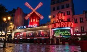 Moulin Rouge, en ikonisk nattklubb i Paris, lyser upp natten med sina neonskyltar och röda väderkvarn.