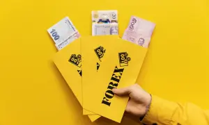 En hand håller gula kuvert märkta "FOREX" med sedlar från Turkiet, Storbritannien och Thailand.