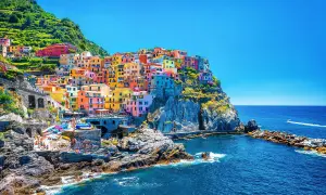 Färgstarka hus klättrar uppför klipporna vid havet, en vy av Cinque Terre, 5 magiska byar.