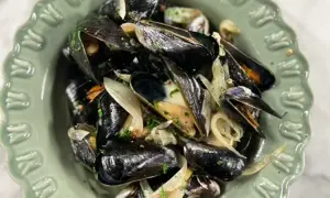 En skål med ångade musslor och lök, perfekt för ett enkelt musslor recept.