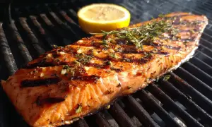 En saftig laxfilé med örter och citron grillas till perfektion. Doften av grillad lax sprider sig i sommarkvällen.