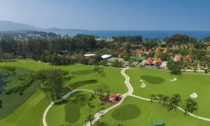 Vacker golfbana i Thailand med gröna fairways, vattenhinder och tropiska träd. En dröm för golfentusiaster.
