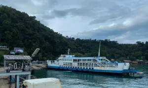 Färja anländer till Koh Chang. Gröna berg och molnigt himmel.