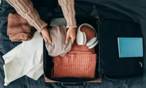 Packa smart! Här ser du vad som kan vara bra att ha i handbagaget på flyget: kläder, hörlurar och en anteckningsbok.