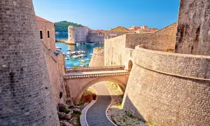 Dubrovniks gamla stad, känd från Game of Thrones, med sina imponerande stadsmurar och en pittoresk hamn fylld med båtar.