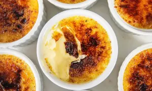 Flera krämiga creme brulee-desserter med karamelliserat sockerlock.
