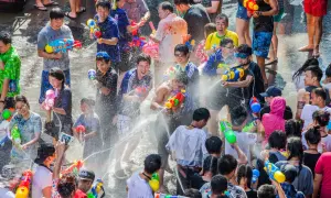 Folk firar Songkran i Thailand med vattenpistoler och glädje.