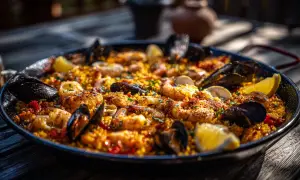 En stor paella med räkor, musslor och citronklyftor. Ett perfekt paella recept för en solig dag.