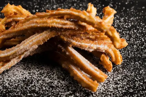 Krispiga, sockerbeströdda churros, perfekta för ett enkelt churros recept.