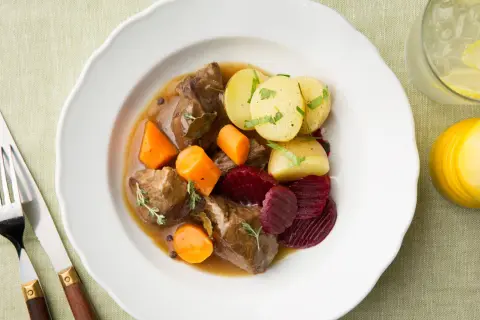 En tallrik med en klassisk kalops med mört kött, rotfrukter och potatis. Perfekt för ett mysigt höstkalas.