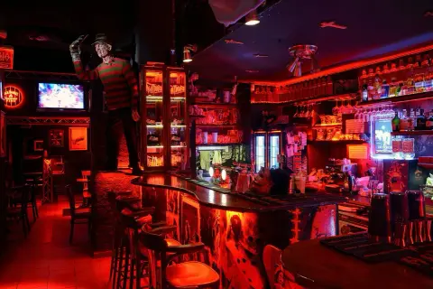 En bar i Prag med Freddy Krueger-tema, rött ljus och en kuslig atmosfär. Perfekt för att hitta de bästa barerna i Prag.