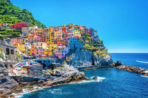 Färgstarka hus klättrar uppför klipporna vid havet, en vy av Cinque Terre, 5 magiska byar.
