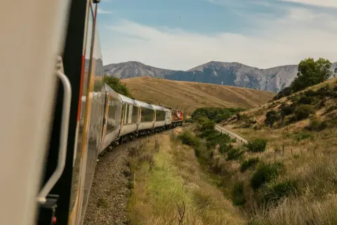 Tåg längs bergiga landskap, en del av spännande interrail-rutter.