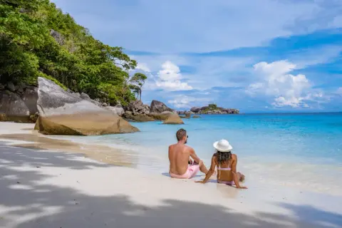 Ett par njuter av den vita sanden och det turkosa vattnet på Similan Island.