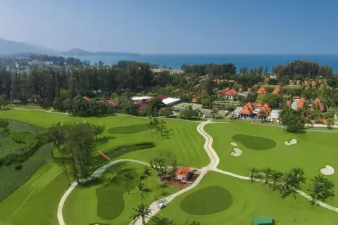 Vacker golfbana i Thailand med gröna fairways, vattenhinder och tropiska träd. En dröm för golfentusiaster.