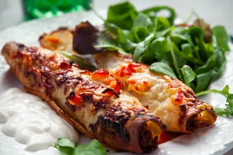 Två gyllene enchiladas med smält ost och en fräsch sallad. Perfekt för ett snabbt enchiladas recept.