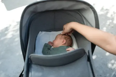Sover sött i barnvagnen, redo för en resa som ett flygplan.