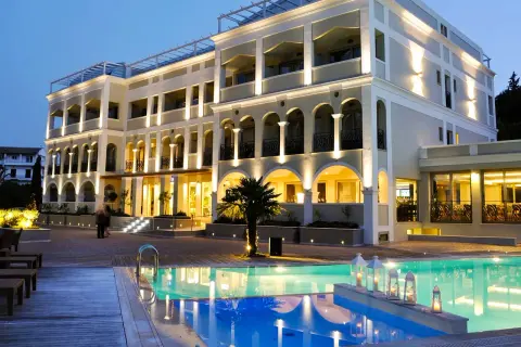 Ett lyxigt hotell med pool och palmer på Korfu. Ving Korfu erbjuder en drömsemester.