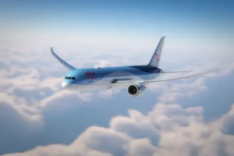 Ett TUI-flygplan flyger över molnen, på väg mot Kap Verde. Flygtiden är snart över.