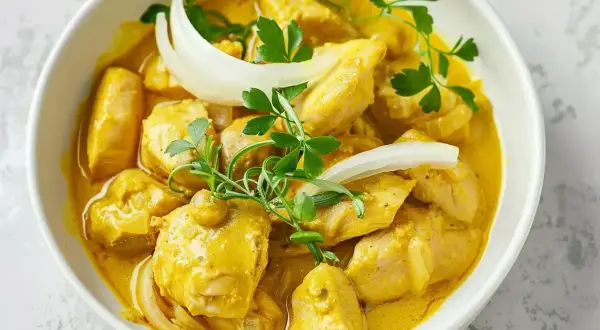 Kyckling i krämig currysås, perfekt för ett snabbt och gott currysås recept. Garnerad med lök och persilja.