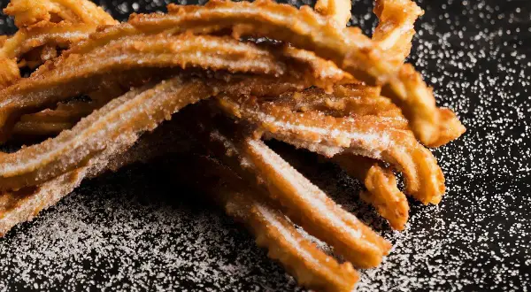 Krispiga, sockerbeströdda churros, perfekta för ett enkelt churros recept.