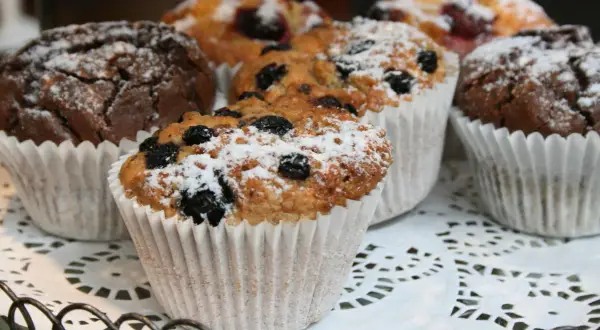 En korg med choklad muffins och blåbärsmuffins, pudrade med florsocker. Perfekt för fikat!