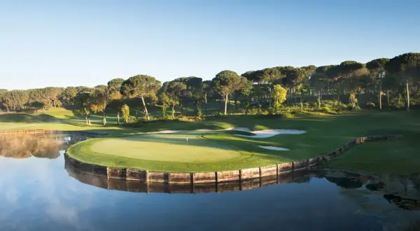 Vacker golfbana vid en sjö, perfekt för en golfhelg i Spanien.