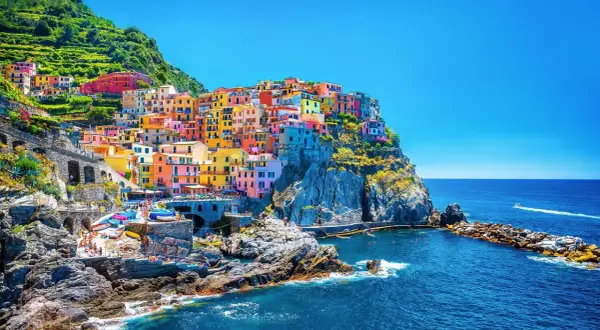 Färgstarka hus klättrar uppför klipporna vid havet, en vy av Cinque Terre, 5 magiska byar.