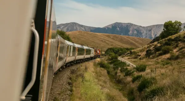 Tåg längs bergiga landskap, en del av spännande interrail-rutter.