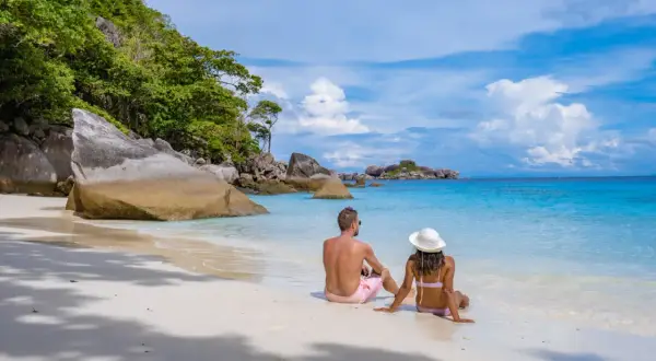 Ett par njuter av den vita sanden och det turkosa vattnet på Similan Island.