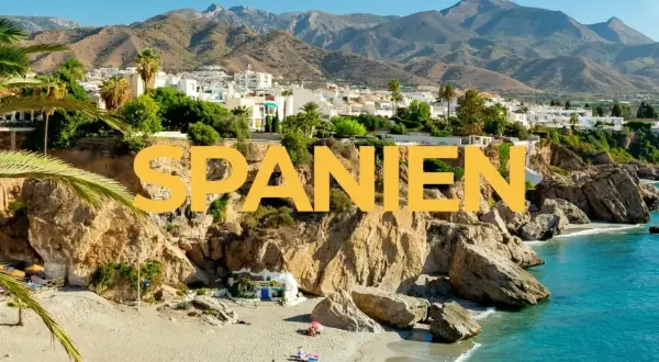 Varmast i Spanien: en solig strand med turkost vatten, klippor och vita hus i bakgrunden.