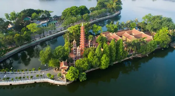 En vacker vy över en pagod och tempelbyggnader på en ö i en sjö, en populär plats i huvudstad i Vietnam.