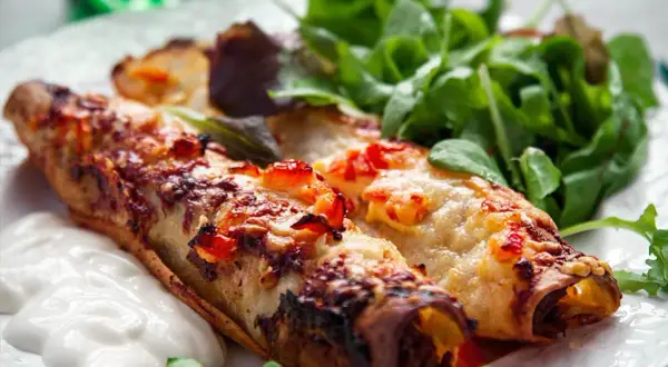 Två gyllene enchiladas med smält ost och en fräsch sallad. Perfekt för ett snabbt enchiladas recept.