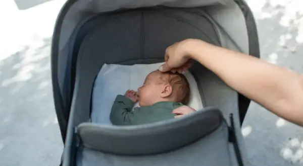 Sover sött i barnvagnen, redo för en resa som ett flygplan.