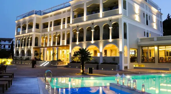 Ett lyxigt hotell med pool och palmer på Korfu. Ving Korfu erbjuder en drömsemester.