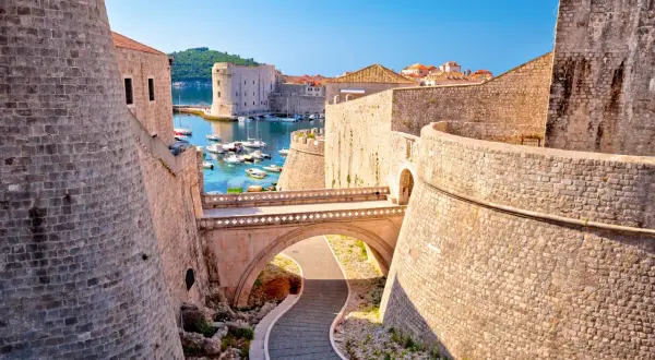 Dubrovniks gamla stad, känd från Game of Thrones, med sina imponerande stadsmurar och en pittoresk hamn fylld med båtar.