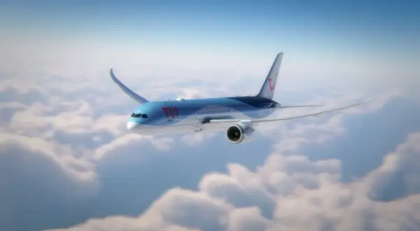 Ett TUI-flygplan flyger över molnen, på väg mot Kap Verde. Flygtiden är snart över.