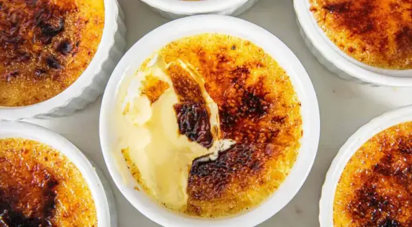 Flera krämiga creme brulee-desserter med karamelliserat sockerlock.