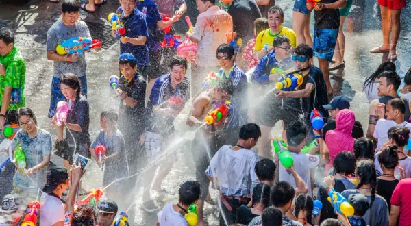 Folk firar Songkran i Thailand med vattenpistoler och glädje.