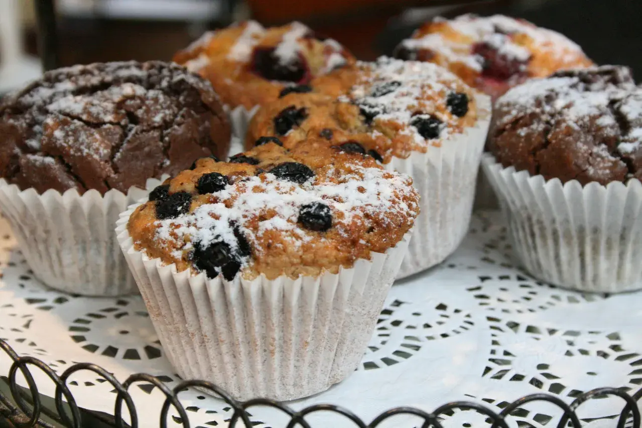 En korg med choklad muffins och blåbärsmuffins, pudrade med florsocker. Perfekt för fikat!