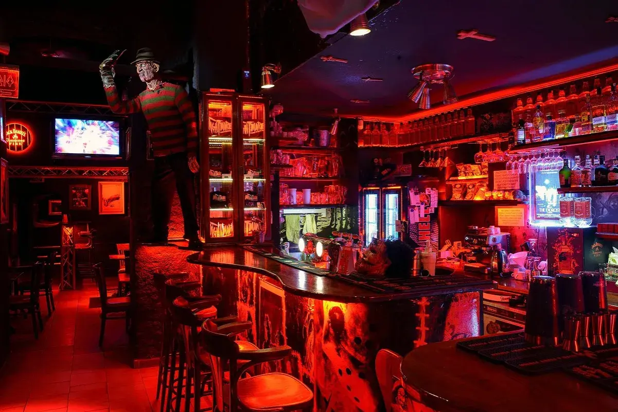 En bar i Prag med Freddy Krueger-tema, rött ljus och en kuslig atmosfär. Perfekt för att hitta de bästa barerna i Prag.