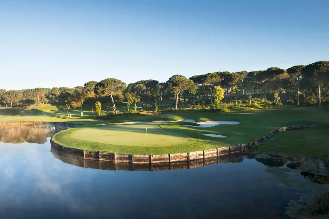 Vacker golfbana vid en sjö, perfekt för en golfhelg i Spanien.