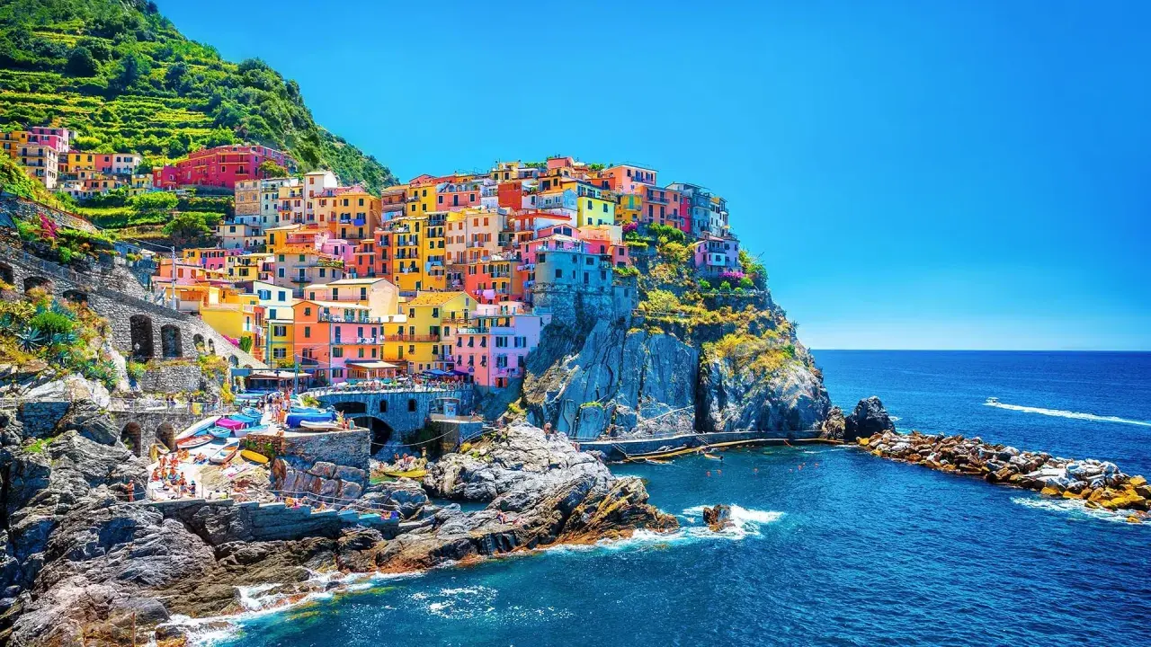 Färgstarka hus klättrar uppför klipporna vid havet, en vy av Cinque Terre, 5 magiska byar.