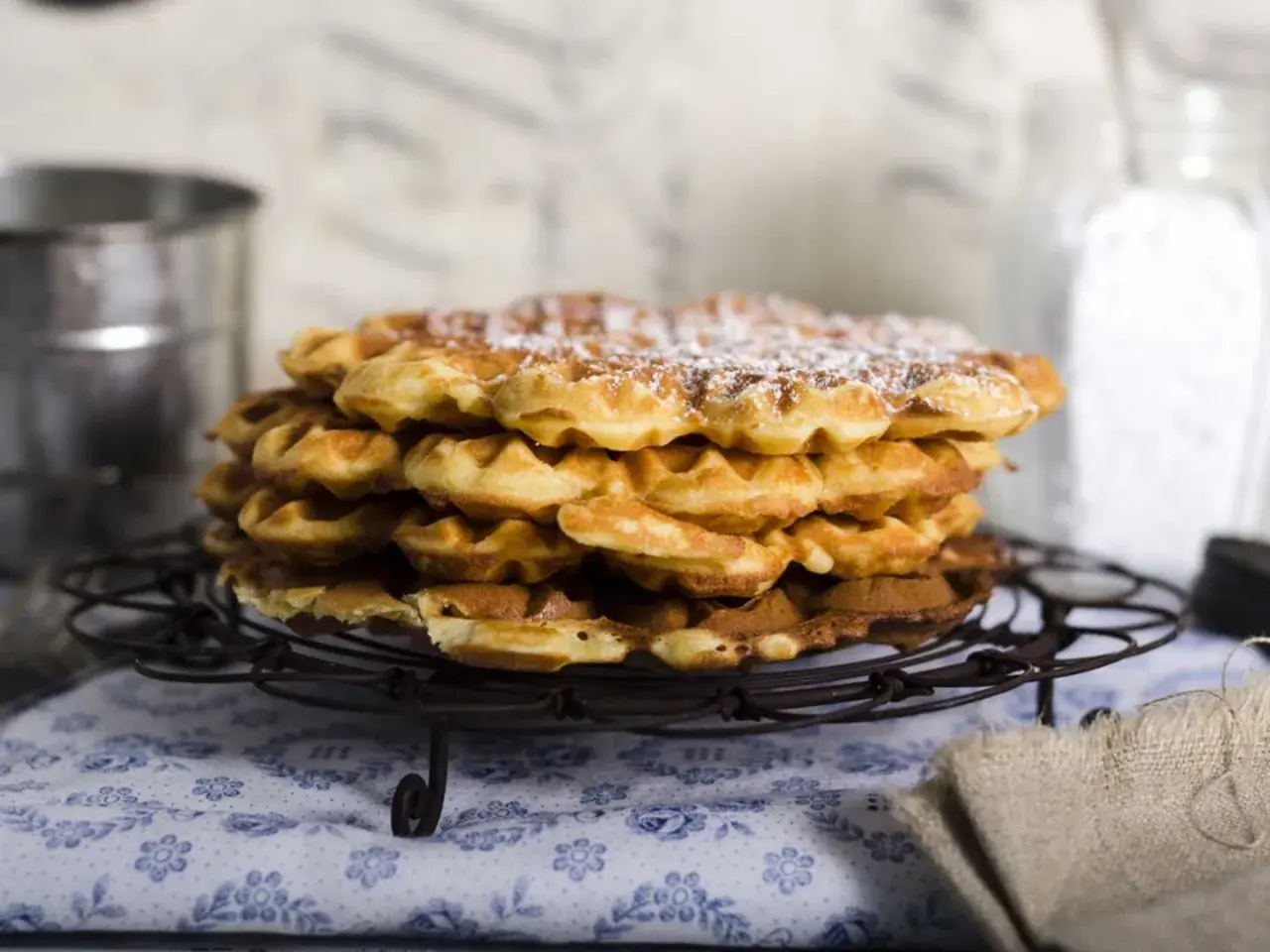 En hög med fluffiga, gyllene frasvåfflor, pudrade med florsocker. Perfekt för ett mysigt fika.