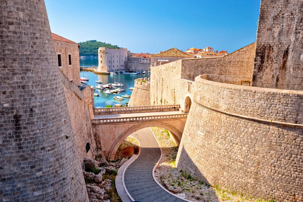 Dubrovniks gamla stad, känd från Game of Thrones, med sina imponerande stadsmurar och en pittoresk hamn fylld med båtar.